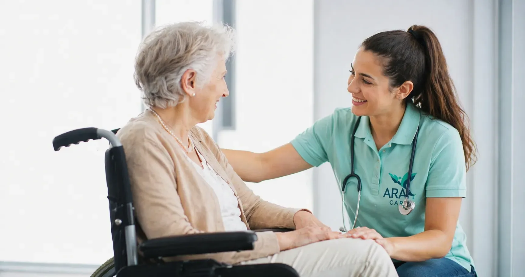 Pflegerin von ARACare im Gespräch mit einer Seniorin im Rollstuhl in Wien