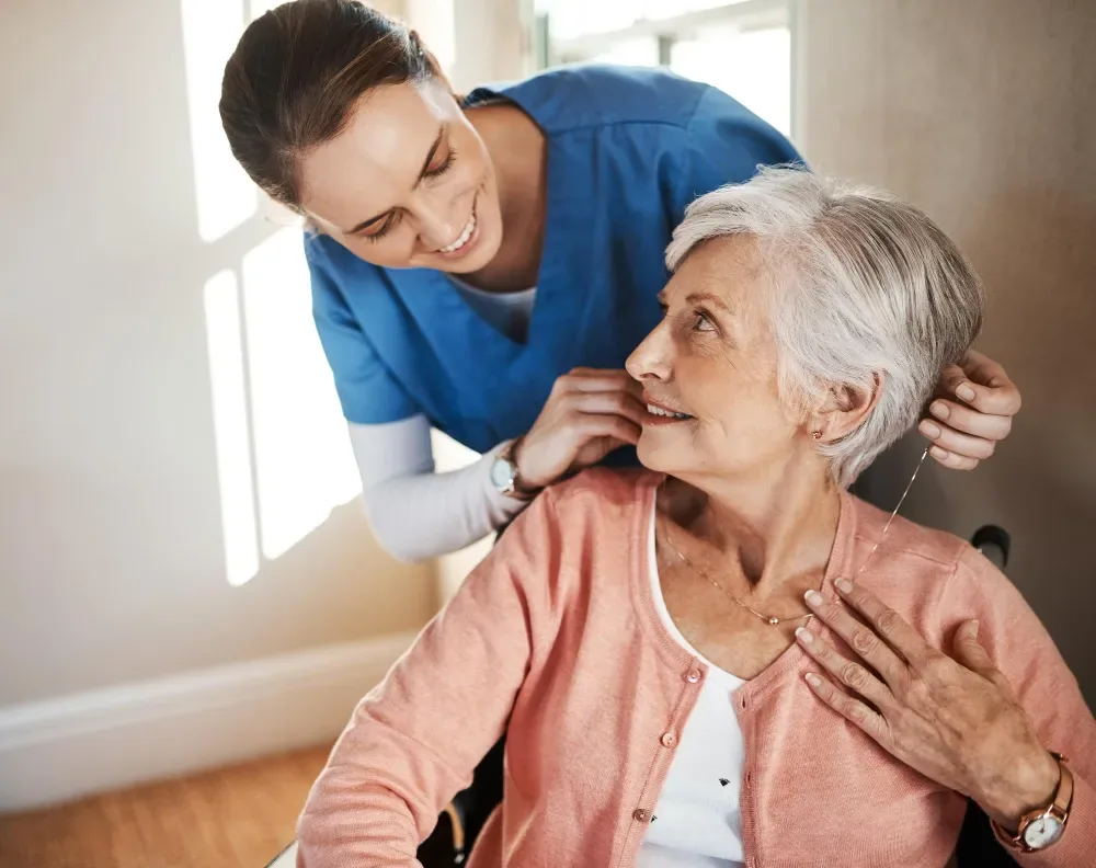 Pflegerin kümmert sich liebevoll um eine Seniorin